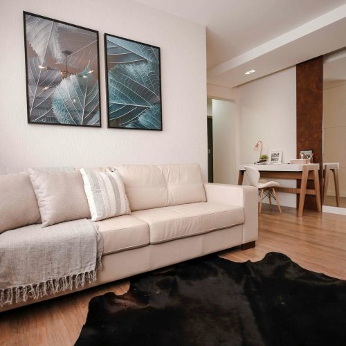 Cozy modern living room with a beige sofa, stylish artwork, and elegant decor.