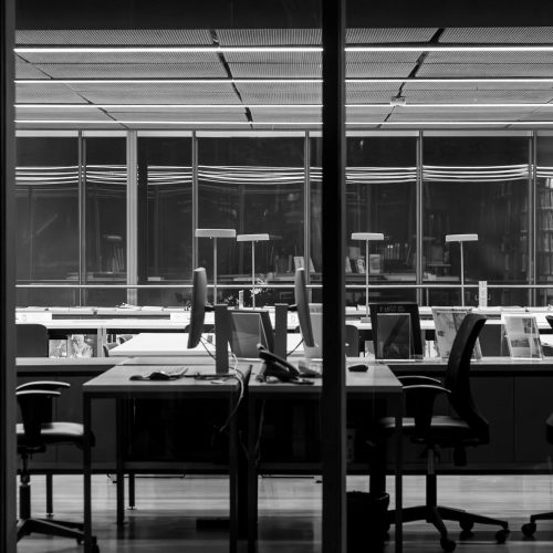 Stylish black and white photo of a modern empty office space, featuring sleek furniture and large windows.