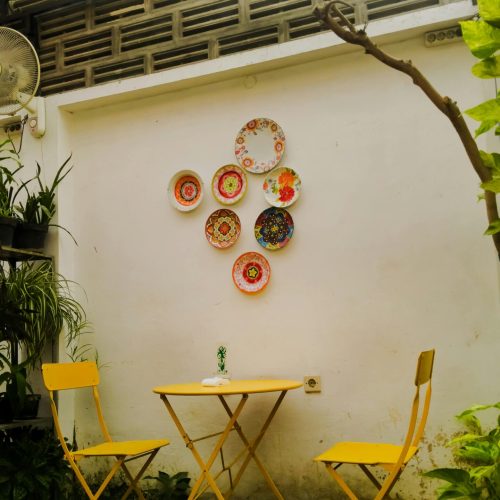 Cozy outdoor cafe nook with yellow chairs, perfect for a serene garden escape.