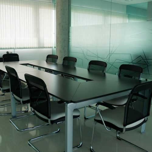 Elegant conference room with sleek black chairs and a modern glass wall design.