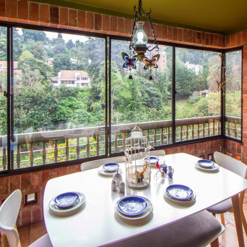 Bright brick-walled dining space with a scenic view and elegant decor.